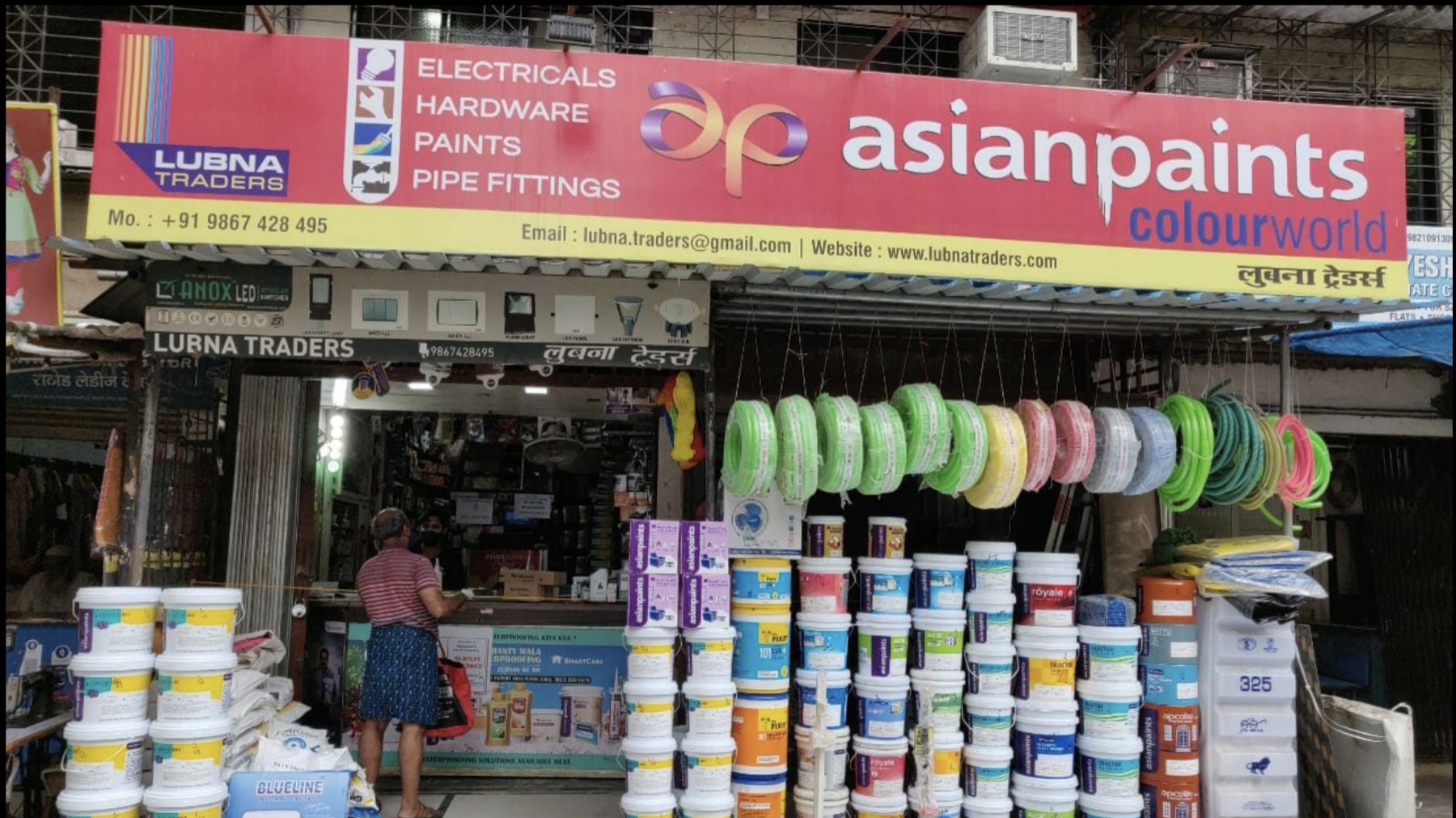 The Lubna Traders shop on Shanti Park Road, with paint buckets and supplies outside